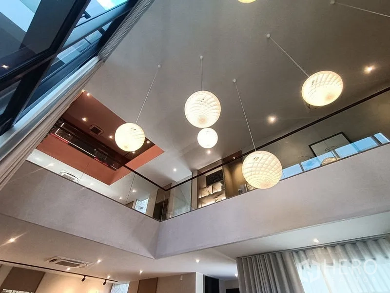 Detached House for sale - Upstairs view of mezzanine with round pendant lights and glass railings.