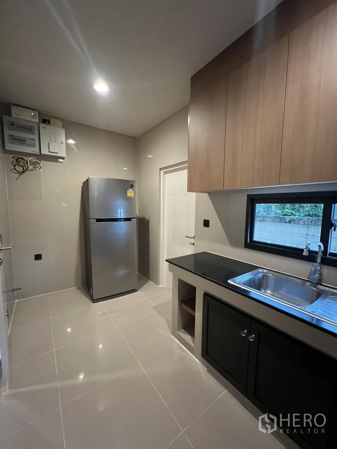 Detached House for rent in Bang Kapi, Bangkok - Kitchen opposite view with refrigerator, window and storage.