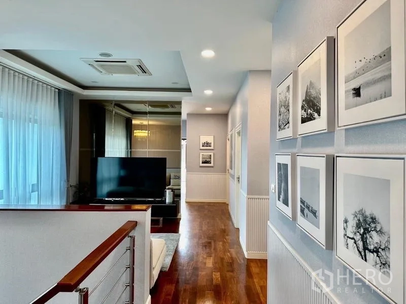 独立式住宅 出租在Lat Krabang, Bangkok - 二层走廊与电视休闲区，木地板和装饰画墙