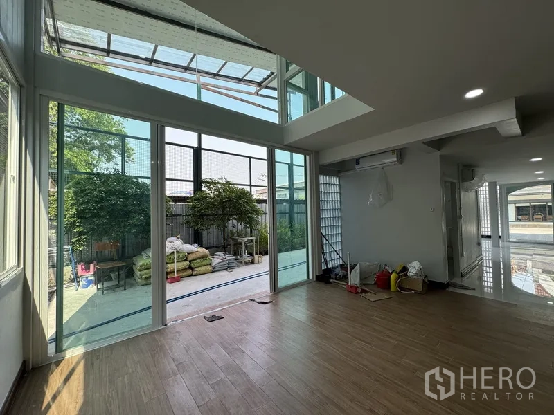 Townhouse for sale in Bueng Kum, Bangkok - Double-height family room with wide glass walls looking onto the private garden.