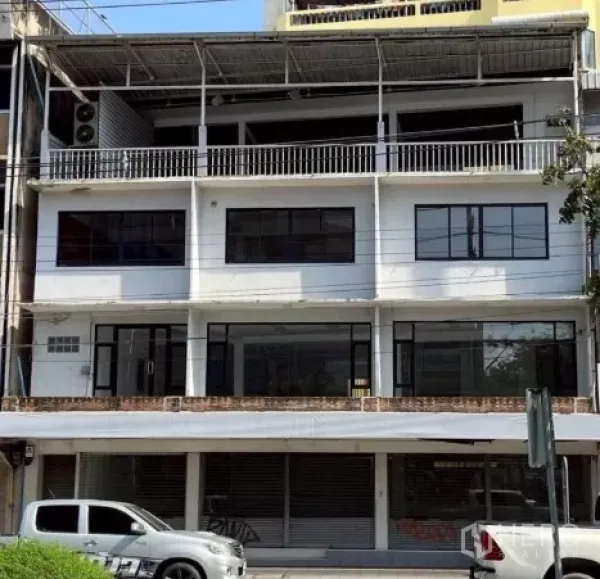 Shophouse for rent or sale in Khlong Toei, Bangkok - Street-front multi-unit shophouse exterior with wide windows and balconies in Khlong Toei.