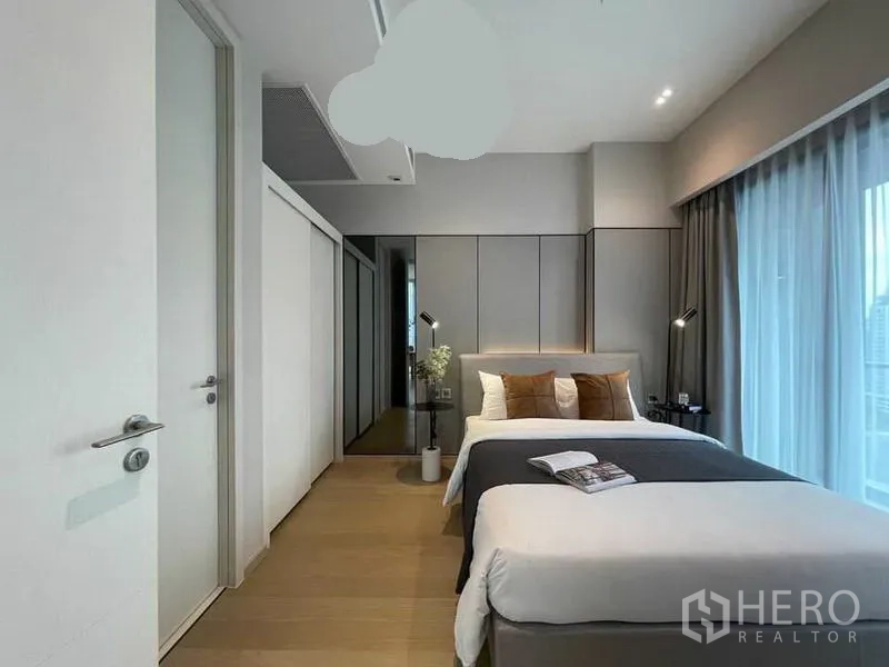 Condominium for rent in Watthana, Bangkok - Second bedroom with twin beds, a wardrobe wall, and sheer curtains.
