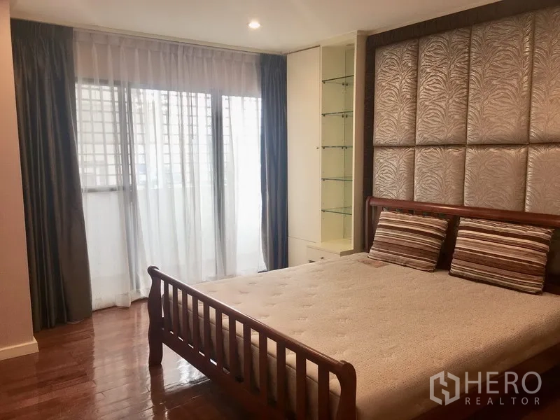 公寓 出租在Watthana, Bangkok - 次卧带木床、软包背景墙、展示柜与大面积采光窗。