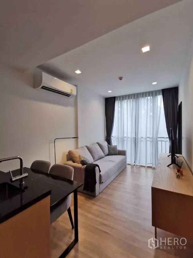 公寓 出租在Watthana, Bangkok - 面向阳台的起居餐区，旁为紧凑型厨房半岛台。