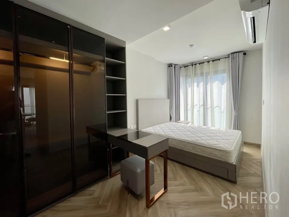 คอนโด for rent in Watthana, Bangkok - ห้องนอนที่สองมีเตียง โต๊ะทำงานพร้อมสตูล และตู้เสื้อผ้าสูงจรดเพดาน