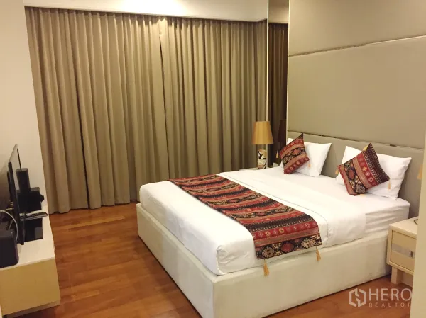คอนโด ให้เช่าในPathum Wan, Bangkok - ห้องนอนมาสเตอร์กว้างขวาง เตียงใหญ่ ตู้วางทีวี และผ้าม่านทึบ
