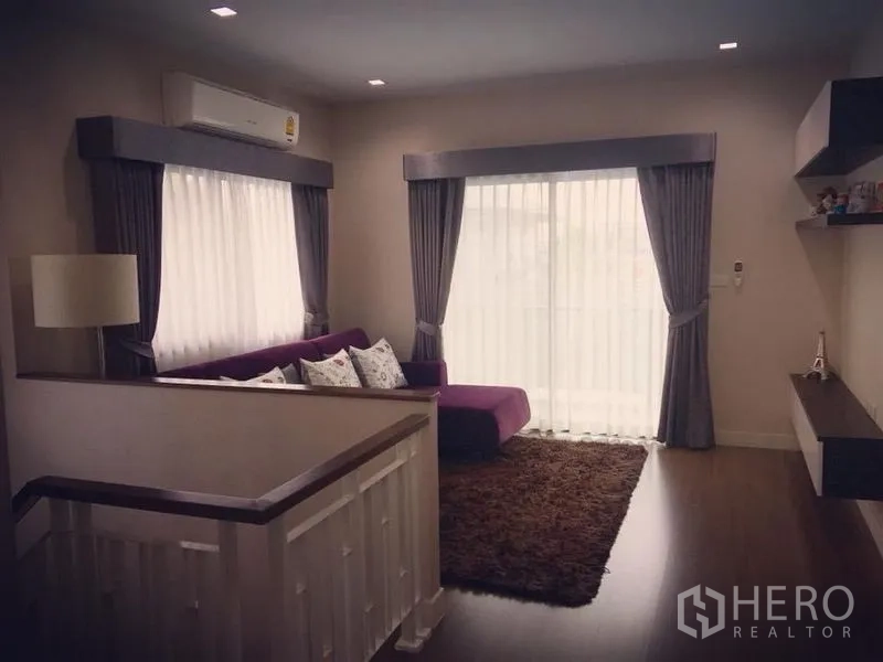 Detached House for sale - Upper-floor lounge with wood flooring and balcony doors framed by curtains.