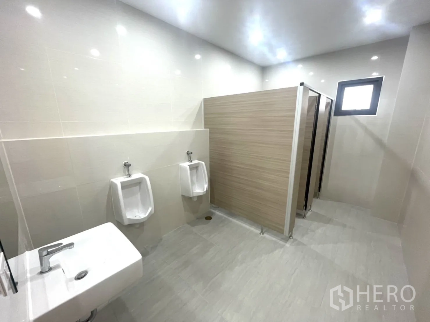 Factory for rent or sale in Bang Yai, Nonthaburi - Male restroom with tiled walls, urinals and partitioned stalls.