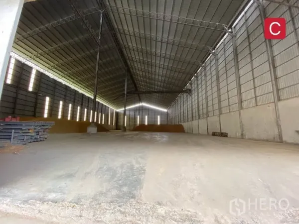 Factory for rent in Chachoengsao - Spacious factory interior with high-clearance steel truss roof, ventilated walls and open concrete floor.
