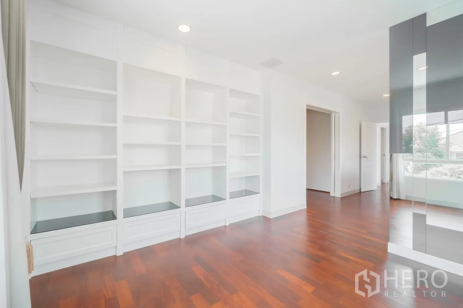 独栋房屋 for rent or sale in Saphan Sung, Bangkok - 采光充足的房间，白色内置书架和木地板。