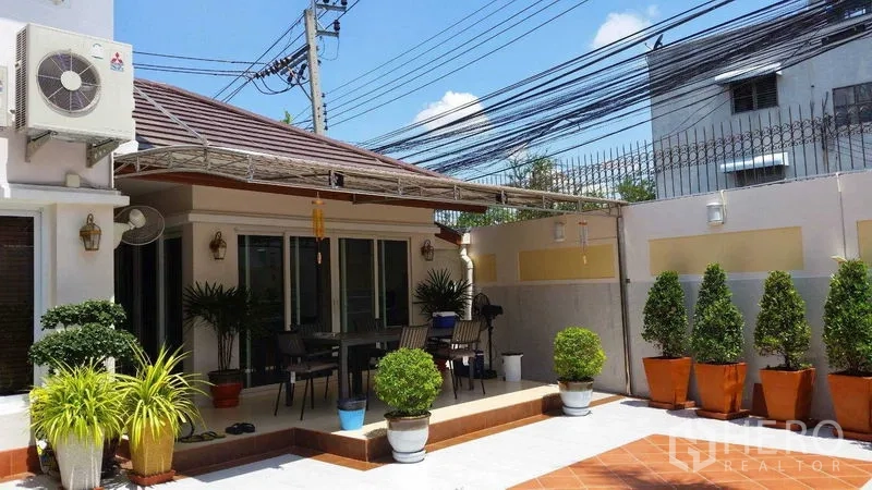บ้าน ขายในSuan Luang, Bangkok - ลานกระเบื้องกว้างพร้อมเฉลียงนั่งเล่นและชุดโต๊ะกลางแจ้ง รายล้อมด้วยกระถางต้นไม้