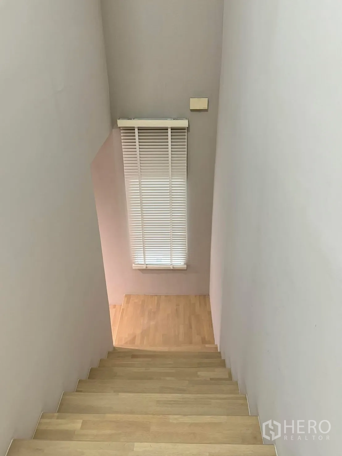 Townhouse for rent in Suan Luang, Bangkok - Wood staircase with window blinds bringing natural light to the hallway.