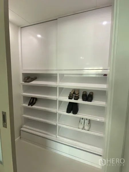 公寓 出租在Watthana, Bangkok - 白色内置鞋柜，层架丰富并配有推拉门。