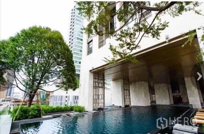 Condominium for rent in Watthana, Bangkok - Condominium outdoor swimming pool beside landscaped garden and shaded pavilion.