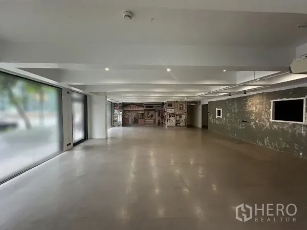 Retail Space for rent in Bang Rak, Bangkok - Open-plan retail interior with polished concrete floor, exposed beams and large street-facing frosted glass windows.