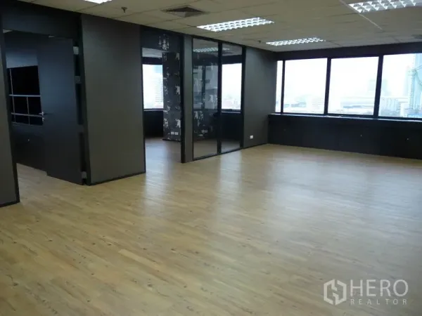 Office Space for rent in Watthana, Bangkok - Open-plan workspace with wood flooring, a glass-partitioned meeting room and large windows with city views.