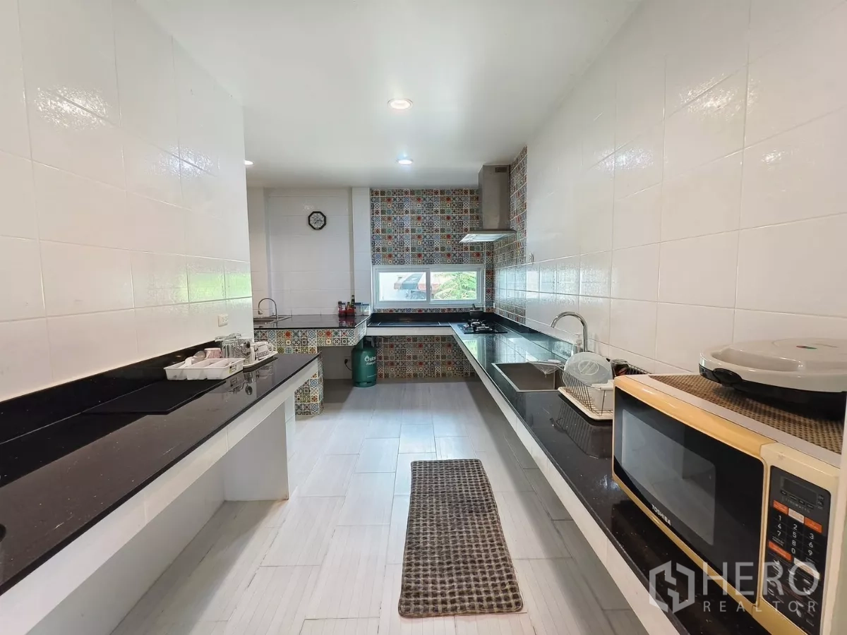 Detached House for rent in Bang Kapi, Bangkok - Another view of bright kitchen with patterned tile accents.