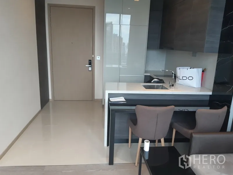 公寓 出租或出售在Watthana, Bangkok - 现代厨区带岛台吧台和两把餐椅。