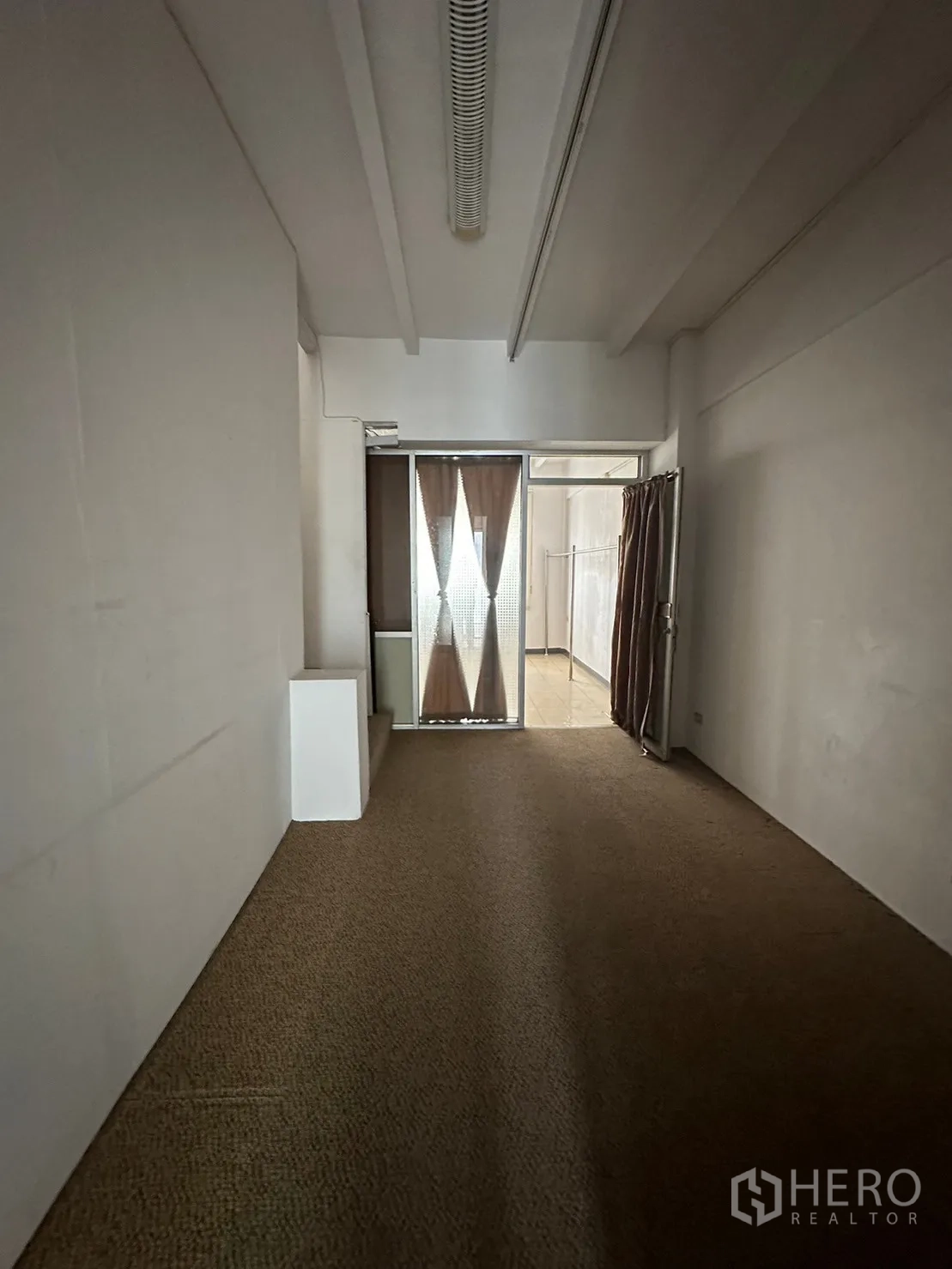 零售空间 出租在Watthana, Bangkok - 狭长房间铺地毯，尽头为玻璃门