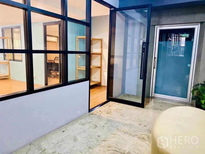 Office Space for rent in Bang Rak, Bangkok - Shared corridor with large glass doors opening into the office.
