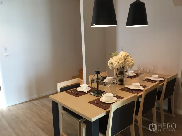 Condominium for sale in Bang Rak, Bangkok - Six-seat dining table under black pendant lights in a modern Bangkok condo.