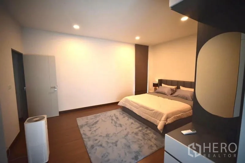 Detached House for rent in Bang Phli, Samut Prakan - Spacious bedroom with double bed, rug and recessed lighting.