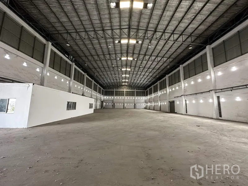Factory for rent in Bang Bua Thong, Nonthaburi - Spacious factory interior featuring high steel‑truss roof, bright lighting, and concrete floor.