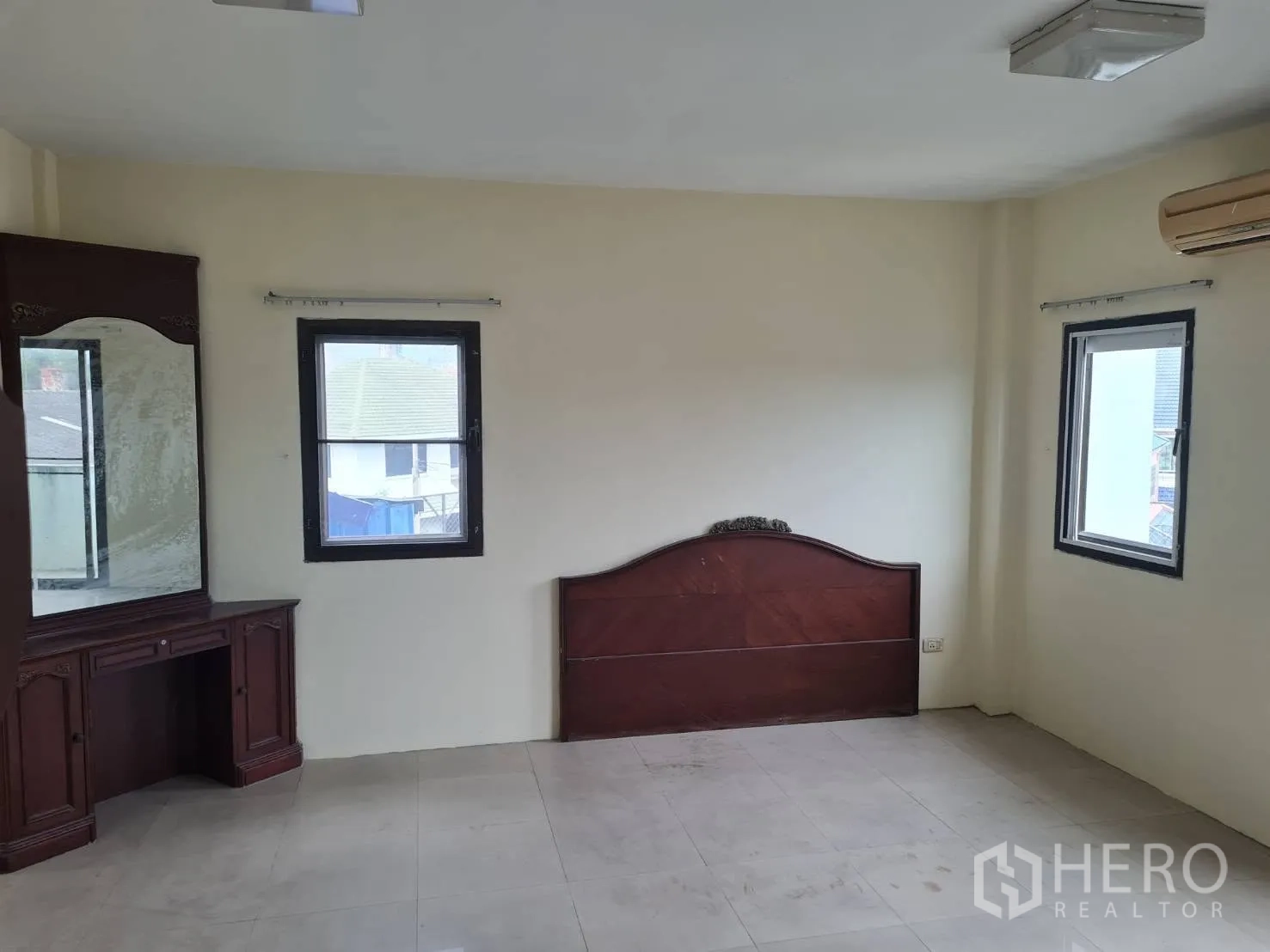 Warehouse for rent in Phra Pradaeng, Samut Prakan - Upper room with windows, wall-mounted air conditioner, and wooden cabinet.