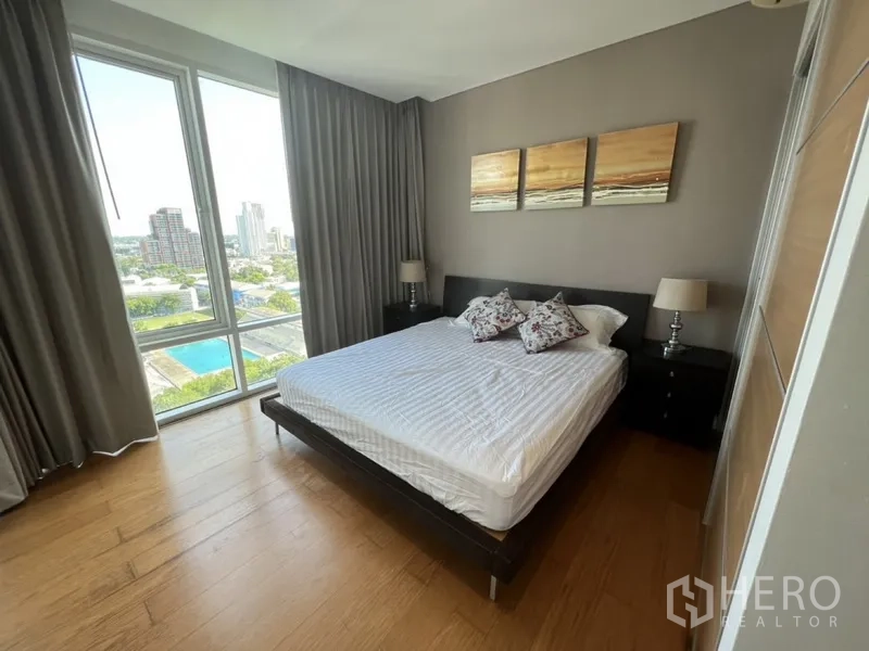 คอนโด ให้เช่าในWatthana, Bangkok - ห้องนอนรองเตียงคิง พื้นไม้ วิวสกายไลน์และสระว่ายน้ำผ่านหน้าต่างสูง