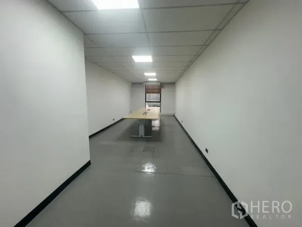 Office Space for rent - Long meeting room with a rectangular conference table and window at the end.