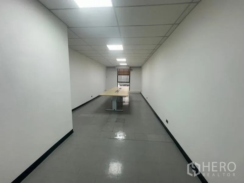 Office Space for rent - Long meeting room with a rectangular conference table and window at the end.