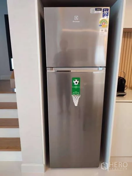 Detached House for rent in Bang Phli, Samut Prakan - Silver top-freezer refrigerator recessed in a niche beside the stairs.