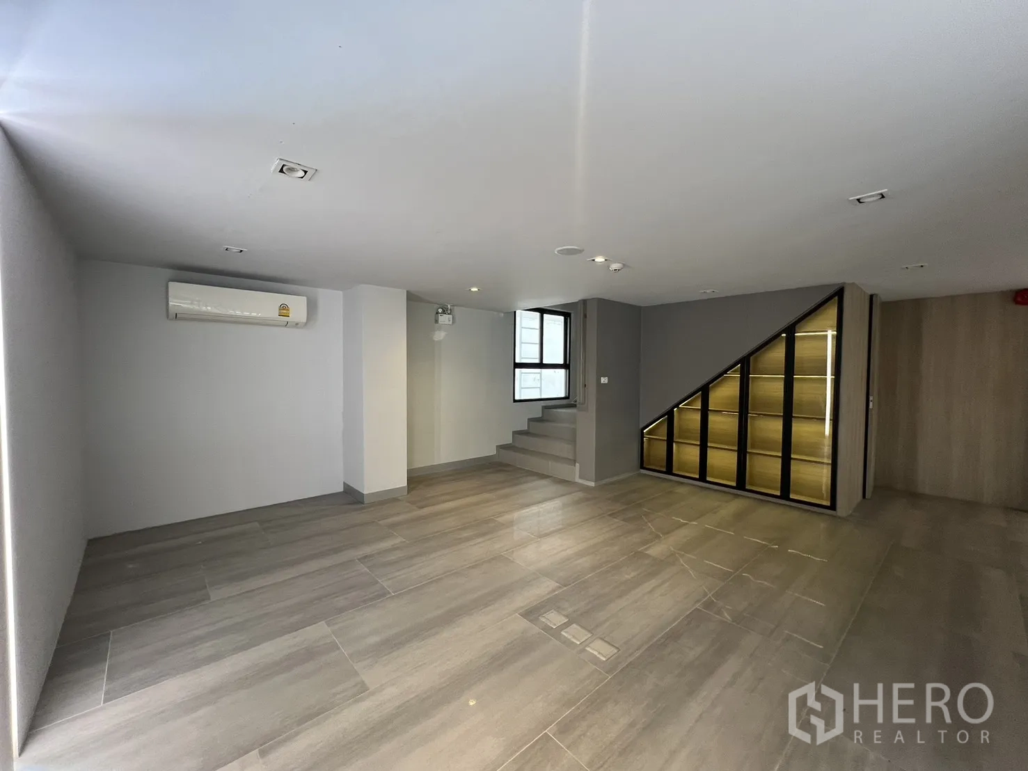 Retail Space for rent in Khlong Toei, Bangkok - Bright mezzanine room with tiled flooring and side stairs.
