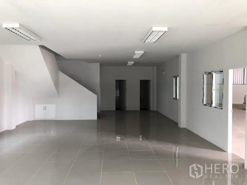 Factory for rent in Samut Prakan - Ground-floor office area with tiled flooring, drop ceilings and stairwell.