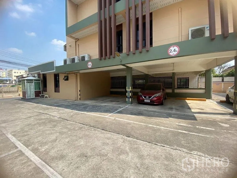 Home Office for rent in Don Mueang, Bangkok - Low-rise home office exterior with covered parking bays and height limit signs.