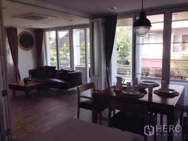คอนโด ให้เช่าในHuai Khwang, Bangkok - ห้องนั่งเล่น–ทานข้าวเชื่อมต่อระเบียงด้วยประตูกระจก มองเห็นวิวสีเขียว