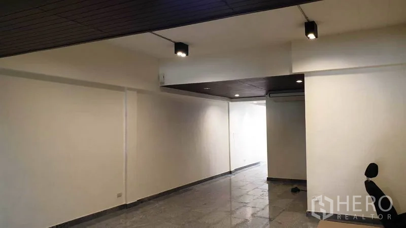联排别墅 出租或出售在Khlong Toei, Bangkok - 一层长形客厅，嵌灯与抛光地砖。
