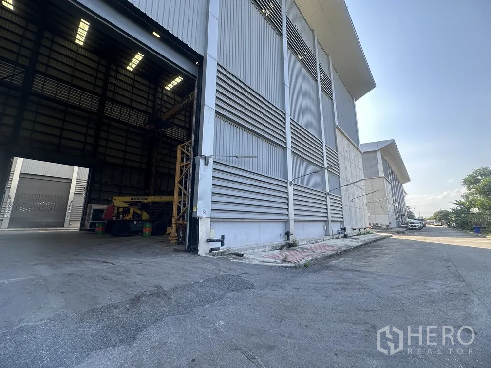 工厂 for rent in Lam Luk Ka, Pathum Thani - 一排现代厂房，配卡车通行车道。