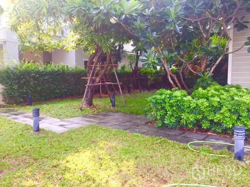 Detached House for sale in Lat Krabang, Bangkok - Landscaped garden with lawn, mature trees, paved path and bollard lights.