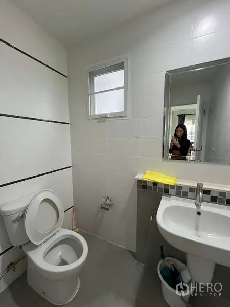 独立式住宅 出租在Bang Kapi, Bangkok - 一层卫生间，设坐便、洗手盆与墙镜。