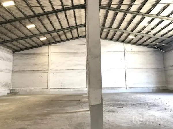 货栈 出租在Lat Krabang, Bangkok - 仓库内开阔储存区，金属屋面、白色围墙与结构立柱。