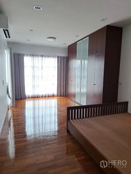 独立式住宅 出租在Prawet, Bangkok - 宽敞主卧，带内置衣柜、木地板与大窗。