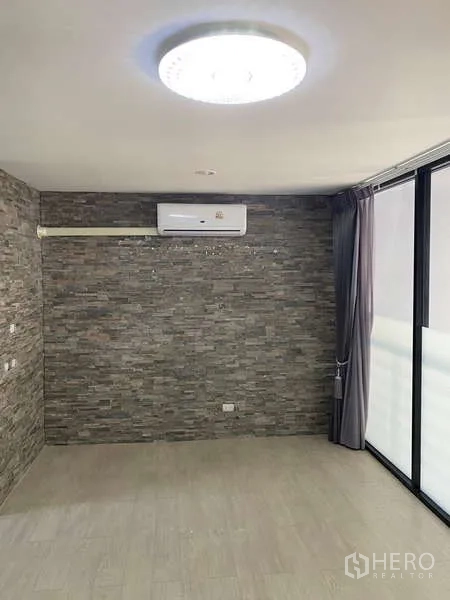 สำนักงานที่บ้าน ให้เช่าหรือขาย - ห้องมีผนังลายหิน อุปกรณ์แอร์ และประตูกระจกออกระเบียง
