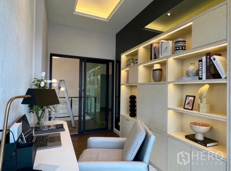 Detached House for sale in Bang Phli, Samut Prakan - Home office with long desk, backlit bookshelves and sliding glass doors.