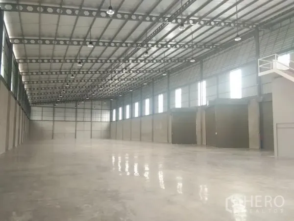 货栈 出租在Bang Phli, Samut Prakan - 仓库内部大跨度无柱空间，高钢结构屋顶，侧窗采光及多扇卷帘门