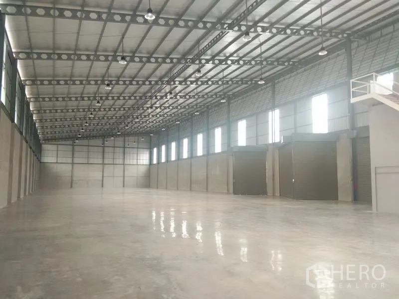 货栈 出租在Bang Phli, Samut Prakan - 仓库内部大跨度无柱空间，高钢结构屋顶，侧窗采光及多扇卷帘门