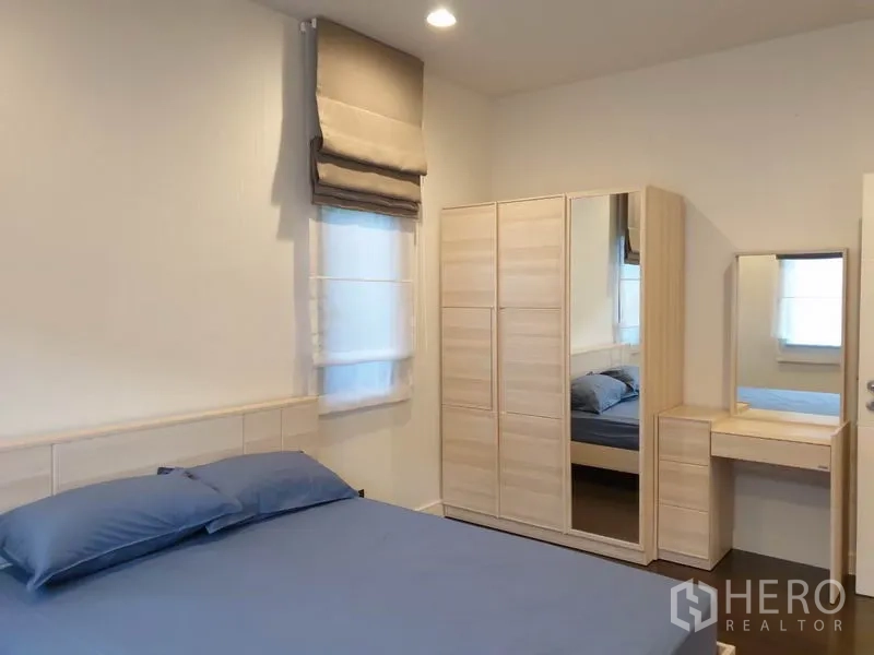 Detached House for rent in Bang Kapi, Bangkok - Cozy bedroom with light-wood wardrobe, dressing table, and soft window shades.