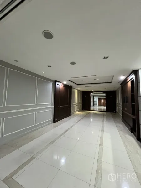 Office Space for rent in Watthana, Bangkok - Long hallway with recessed lighting and decorative wall panels.