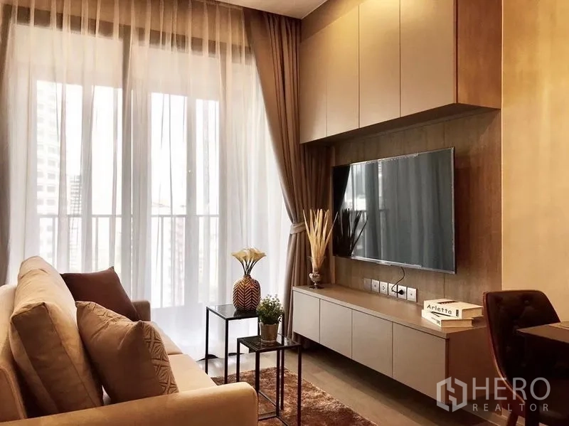 คอนโด ให้เช่าในWatthana, Bangkok - มุมนั่งเล่นผนังทีวี ตู้ลอย และประตูกระจกออกระเบียงพร้อมม่านโปร่ง