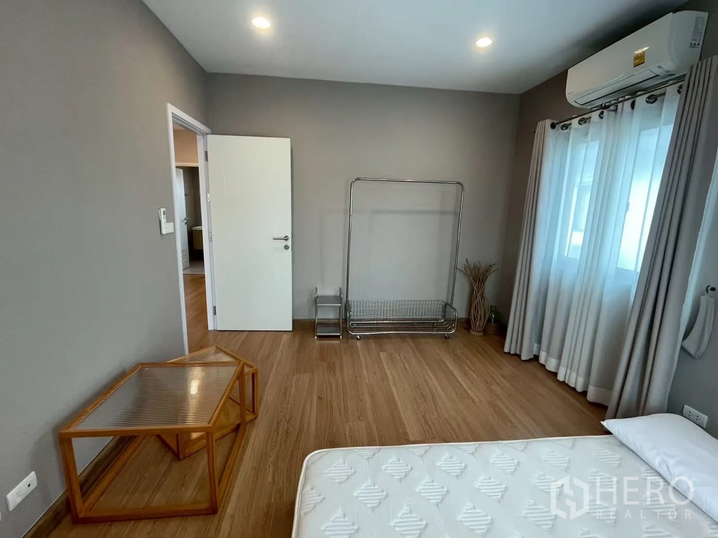 บ้านเดี่ยว for rent in Bang Phli, Samut Prakan - ห้องนอนสว่างพร้อมที่นอน เครื่องปรับอากาศ และราวแขวนเสื้อโลหะ.